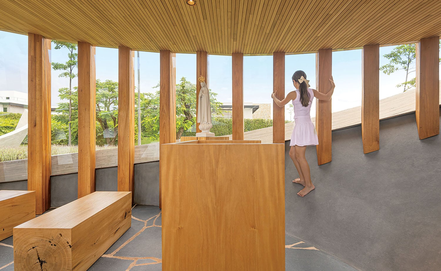 A woman standing in a room with wooden benches.