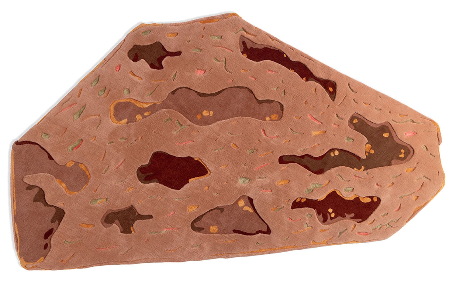 An irregularly shaped rug resembling a slice of bread with various brown and tan patches, and small specks in orange, green, and yellow.