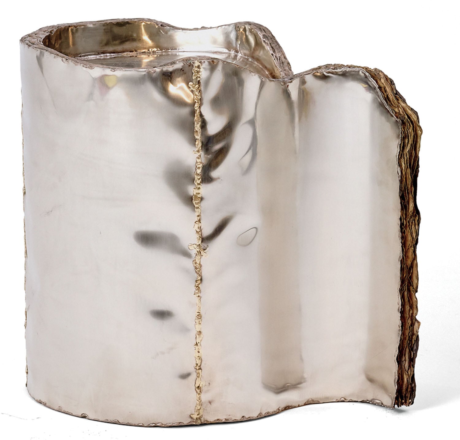 A polished metallic sculptural object with an irregular, undulating shape and visible welded seams, featuring a textured edge on one side.