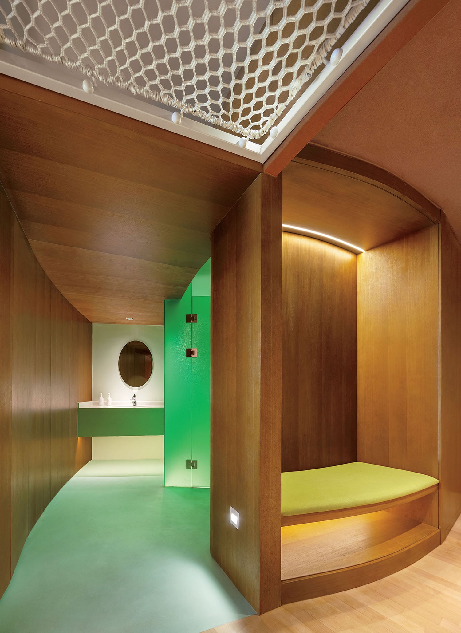 A room with a bed and a green wall.