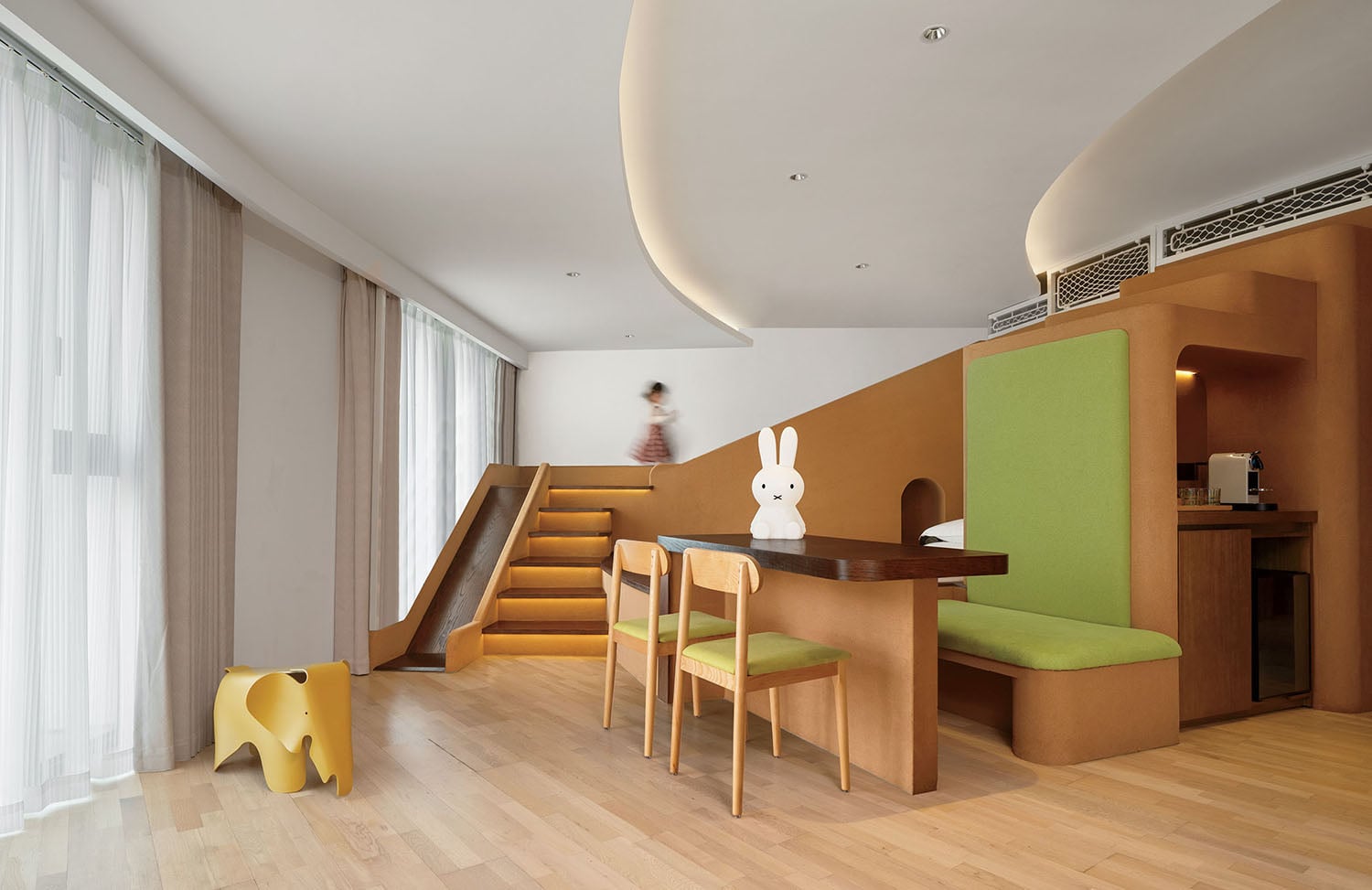 A room with a green couch and a wooden table.