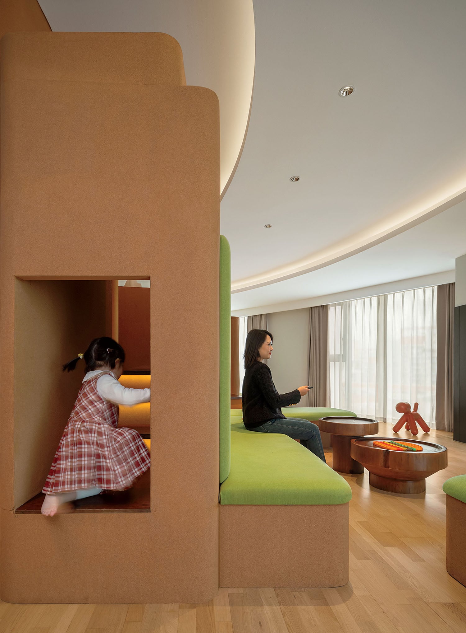 A woman sitting in a room with a green couch.
