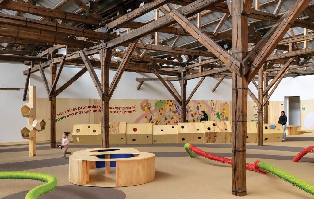 A large room with a wooden structure and a large wooden table.