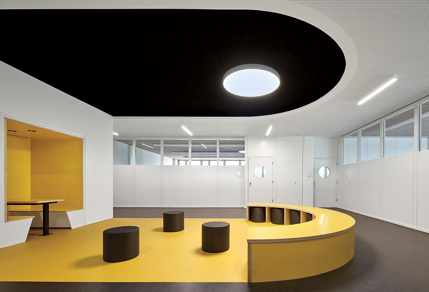 A yellow and black office with a round table.