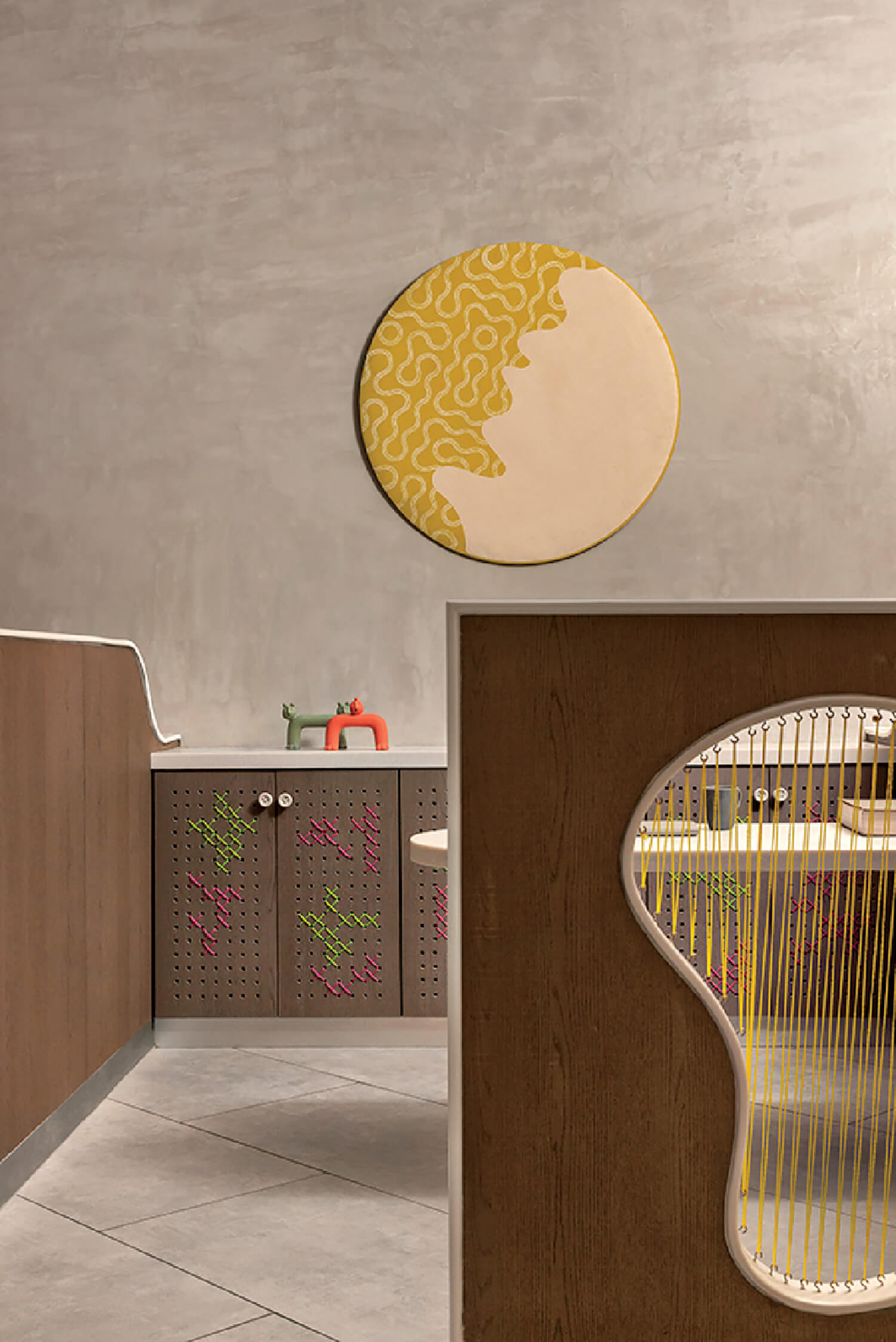 A modern interior with wood paneling, geometric tiles, a yellow and cream abstract wall art piece, and a partition featuring an irregular cutout with yellow string details.