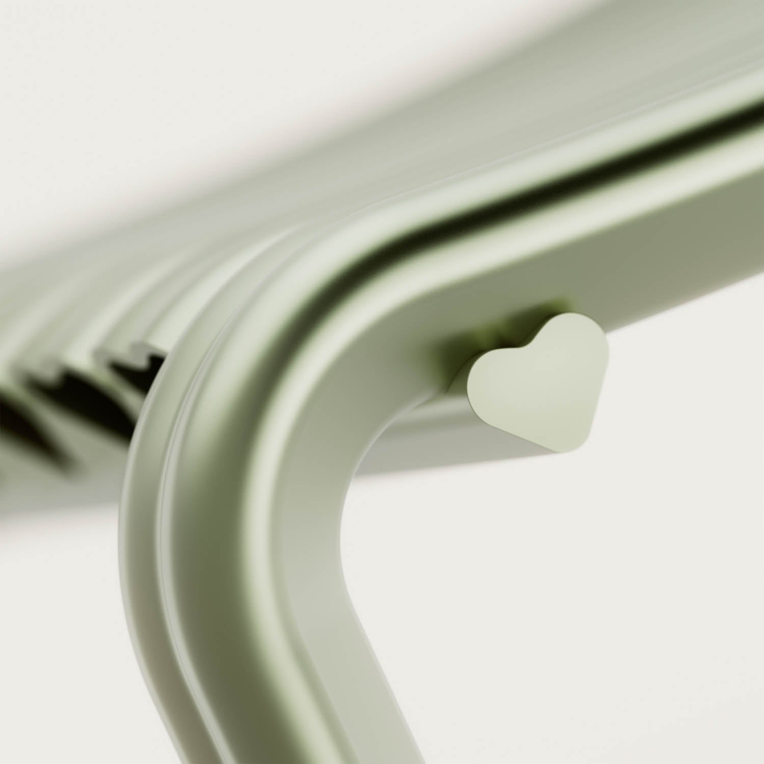 Close-up of a light green metal chair with a heart-shaped detail on the side of its frame.