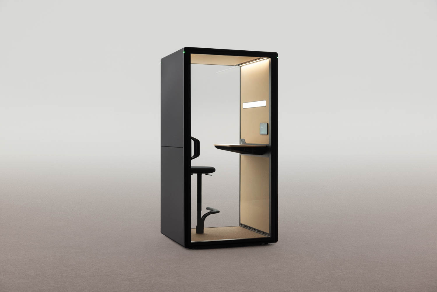 A modern, black Framery phone booth with a built-in stool, small desk, and light, designed for privacy in open spaces.