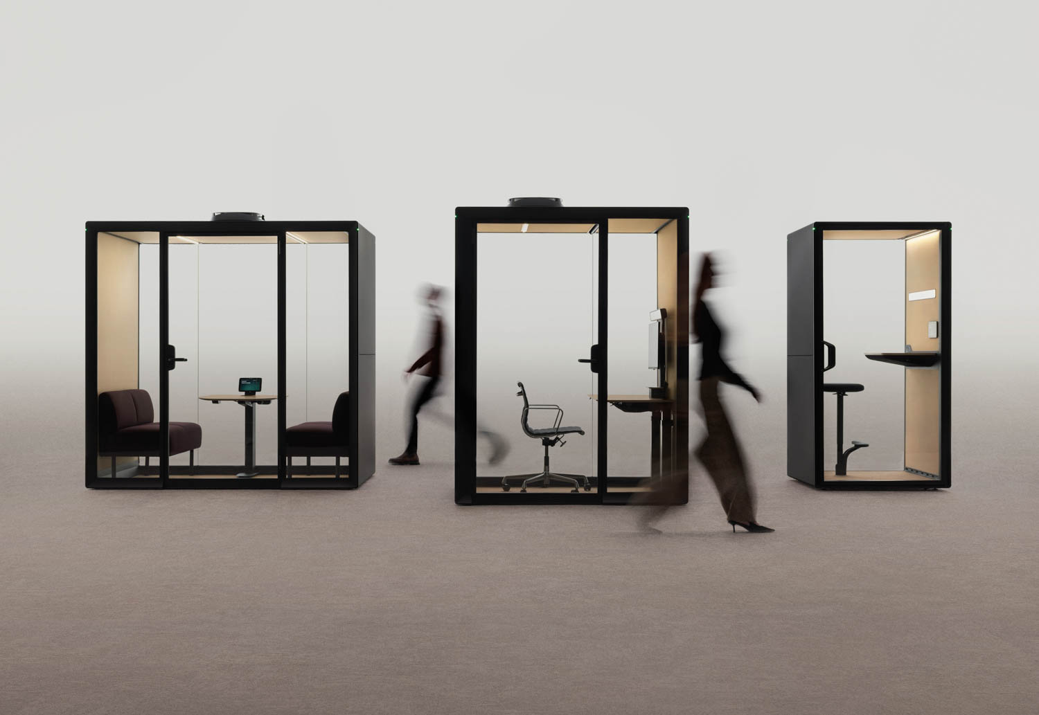 Three framery glass office pods with minimalist furniture are shown side by side; blurred figures walk past and inside the pods.