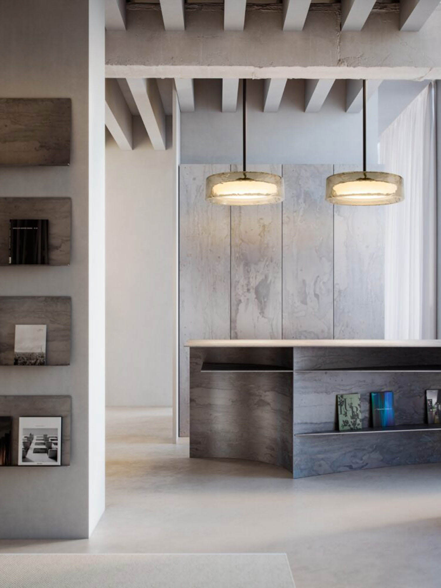 Modern minimalist interior with exposed beams, hanging lights, a wooden counter, and shelves displaying books and magazines.