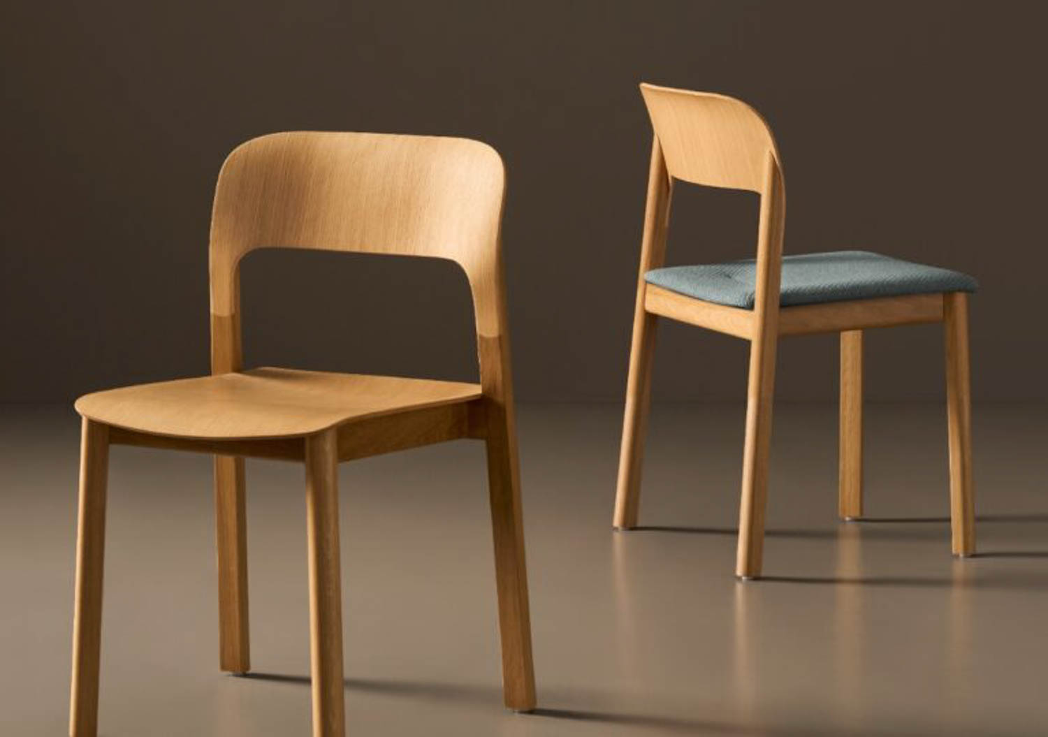 Two wooden chairs are shown; one has a plain wooden seat and the other has a padded fabric seat. Both have curved backrests and simple, modern designs.