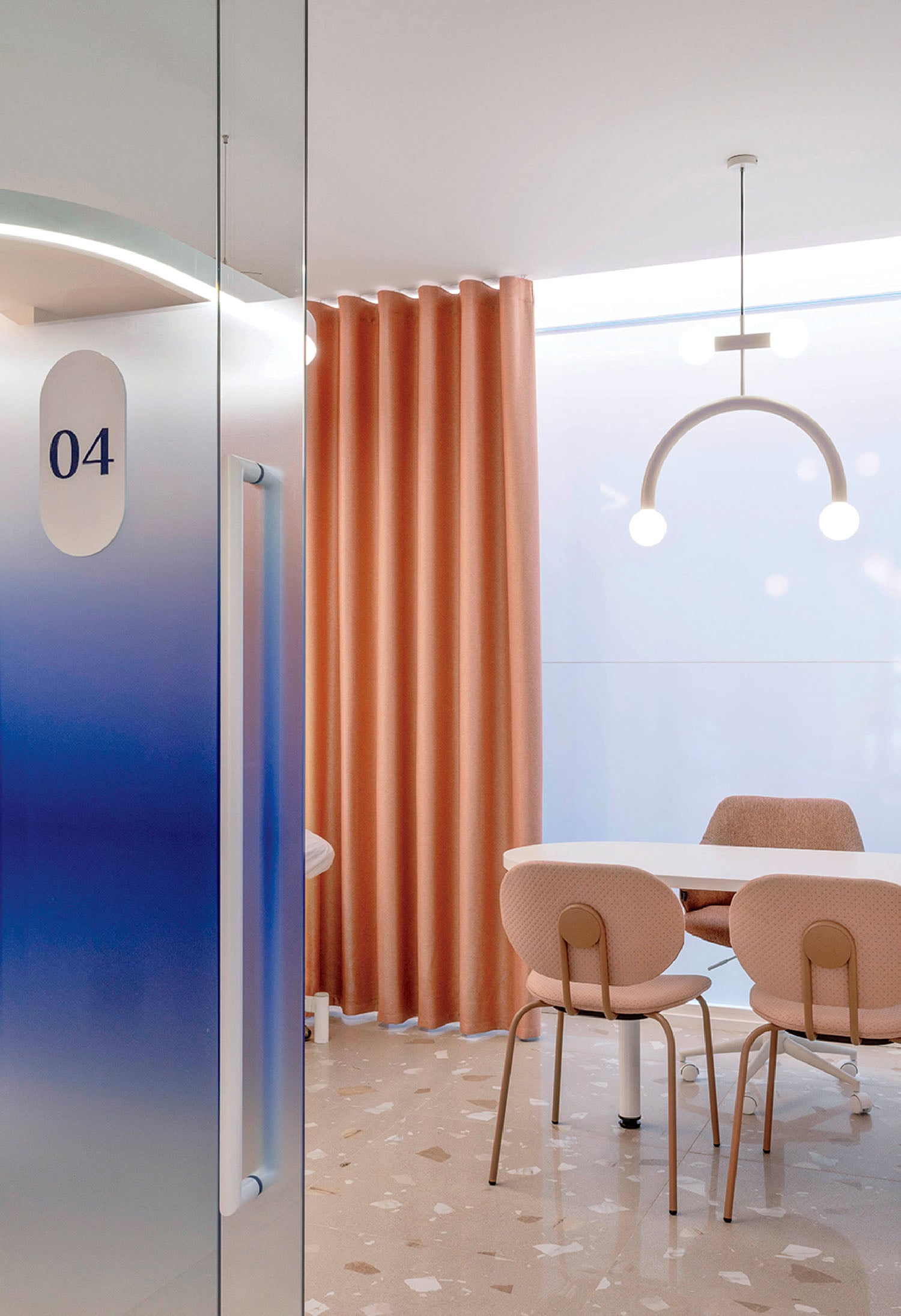 Modern meeting room with peach-colored chairs, a white table, geometric chandelier, terrazzo floor, peach curtains, and frosted glass door labeled "04.