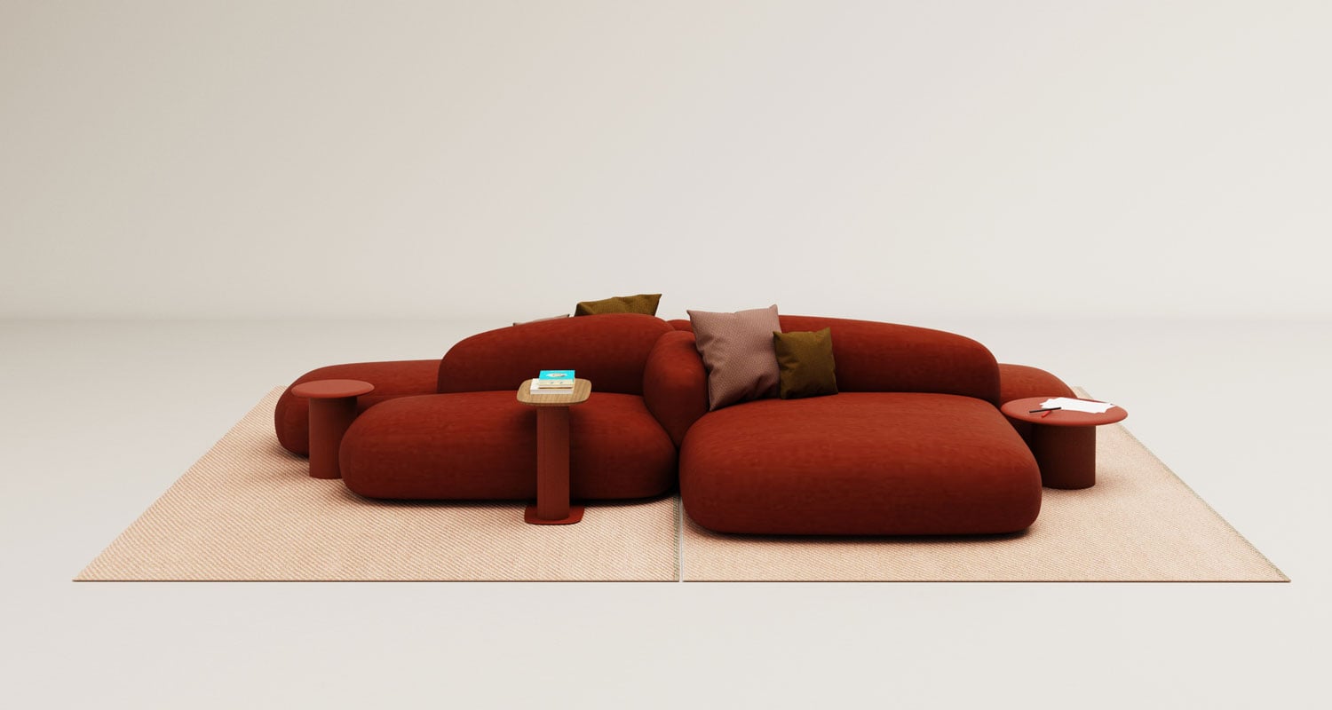 A modern red modular sofa with brown and beige cushions is placed on two beige rugs, accompanied by small matching round side tables holding a book and a notepad.