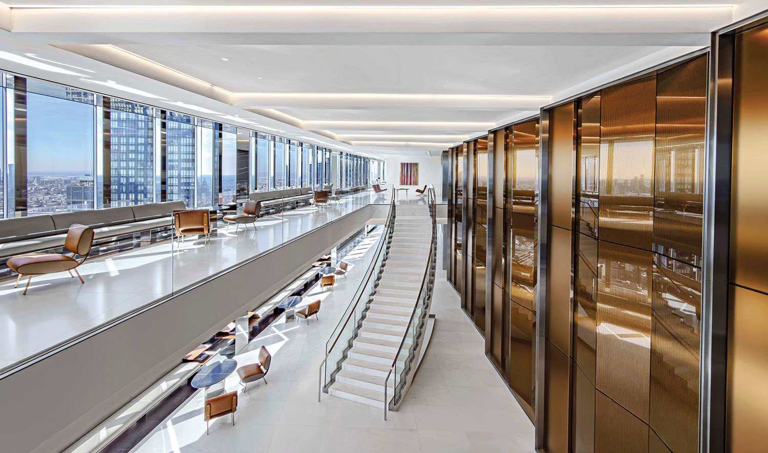 Modern office interior with floor-to-ceiling windows, a grand white staircase, gold-paneled walls, and seating areas with brown chairs and tables.