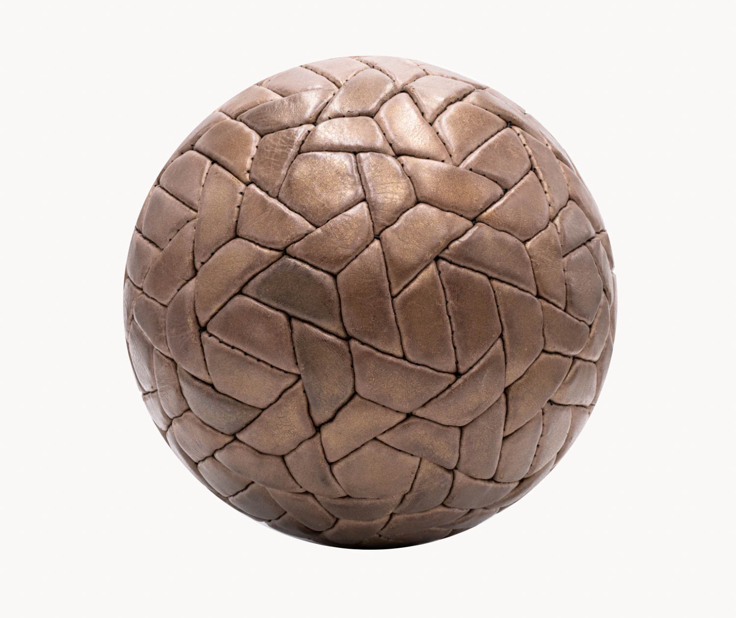 A brown spherical object with an interlocking geometric pattern resembling stitched leather pieces covering its surface.