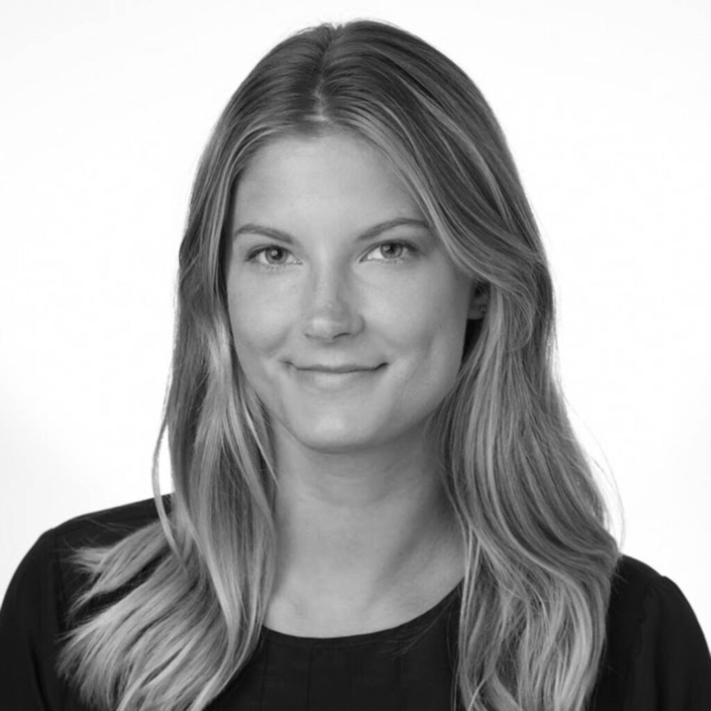 A woman with long, straight hair and a slight smile poses for a professional headshot against a plain, light background.