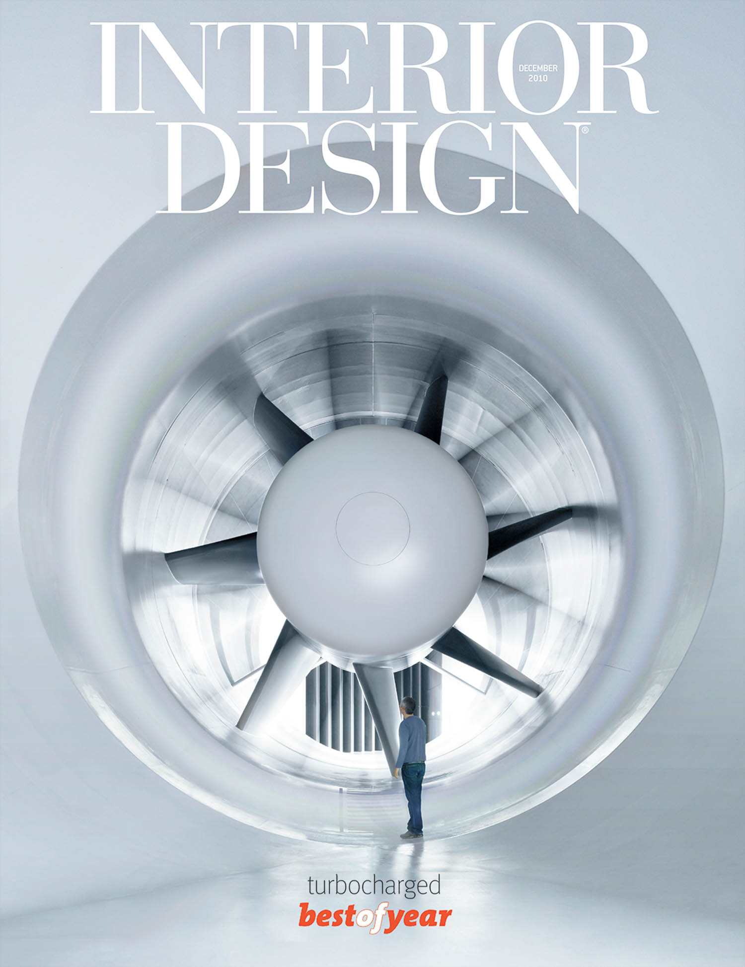 A person stands in front of a large jet engine inside a modern, white space. The cover reads “Interior Design, December 2018, turbocharged, best of year.”.