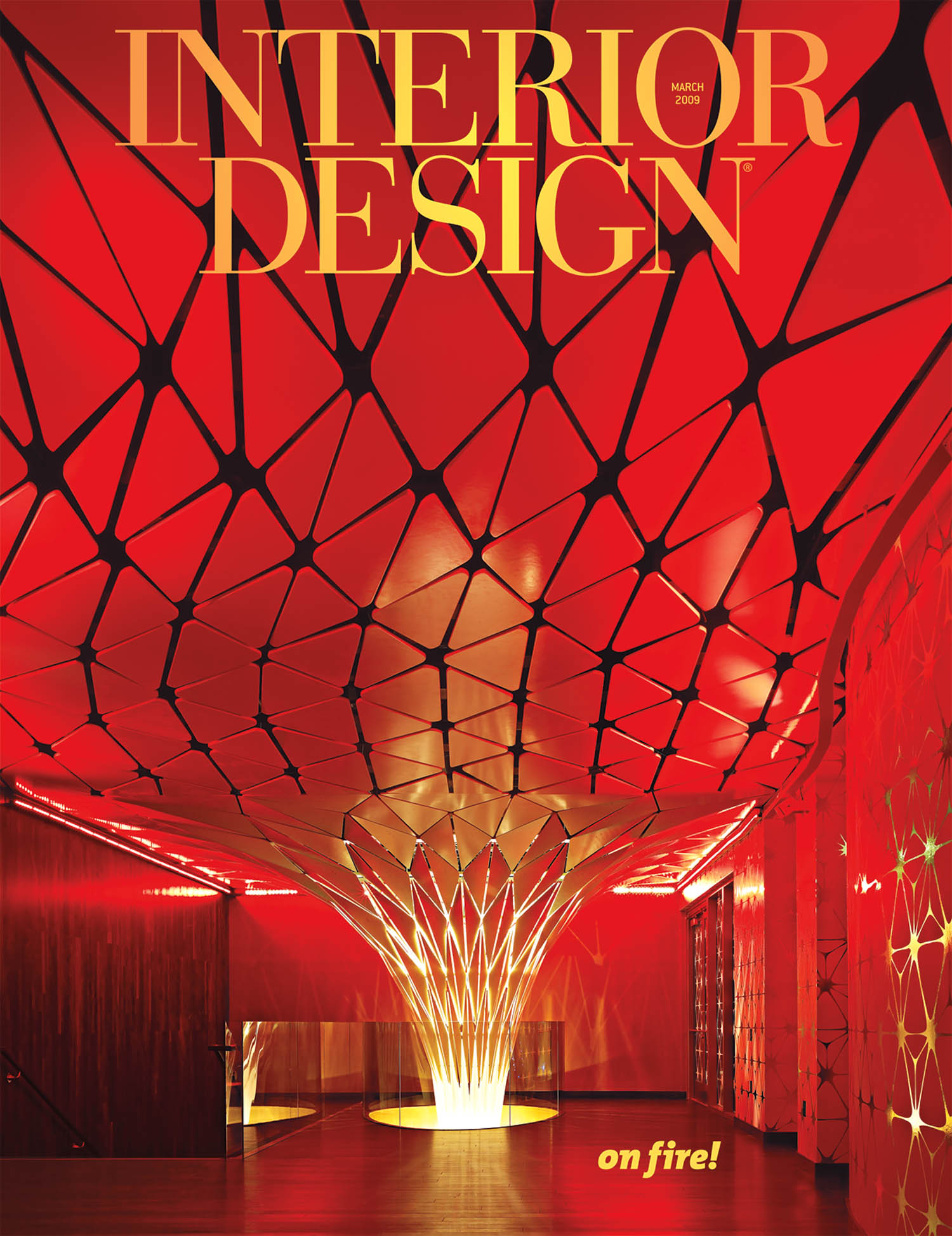 Lobby with geometric red ceiling and illuminated sculptural column, featured on the cover of Interior Design magazine, March 2023. Bold yellow and white text highlights the theme “on fire!”.