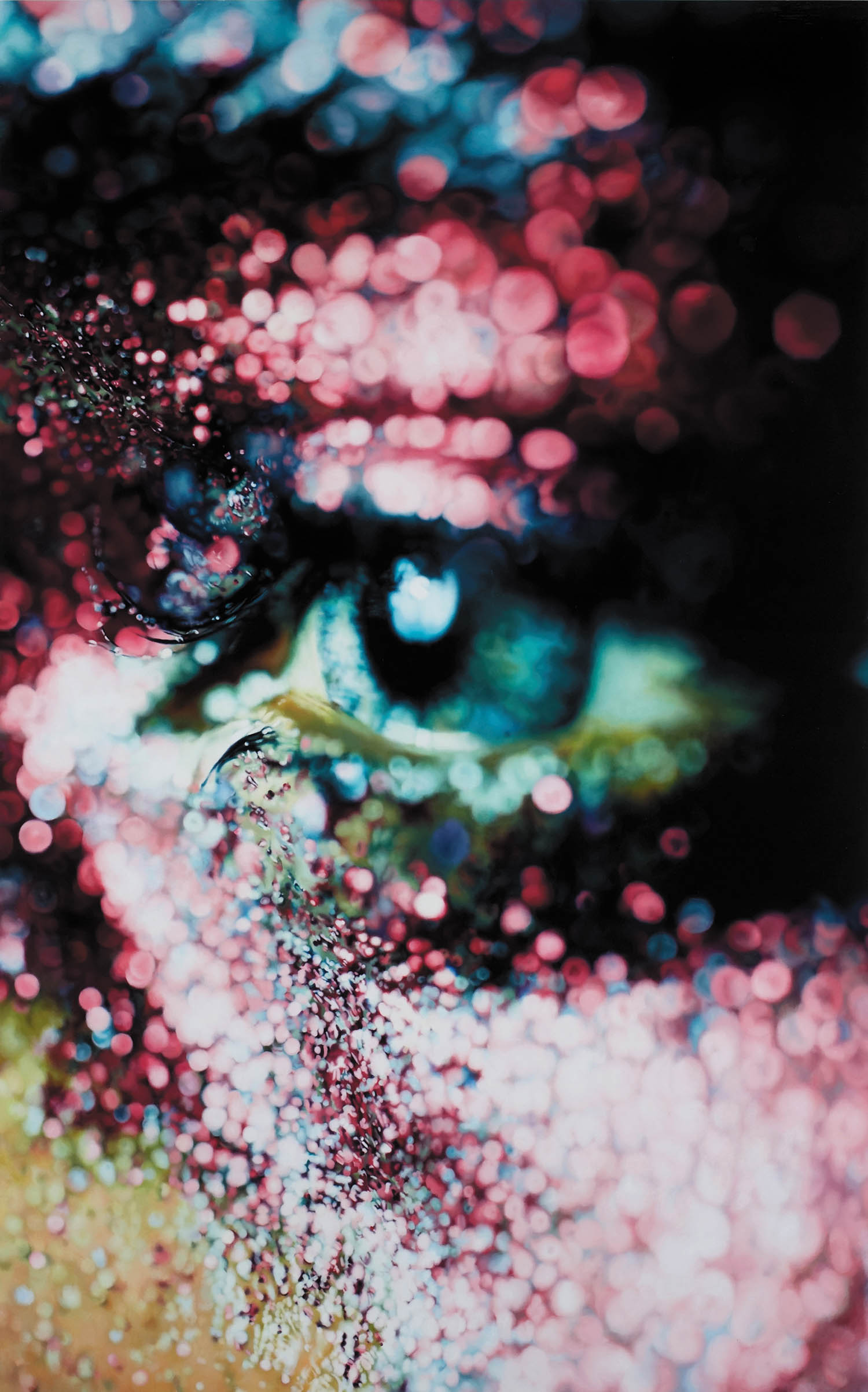A close-up of a person’s eye surrounded by colorful pink, purple, and blue glitter, creating a vibrant and textured appearance.