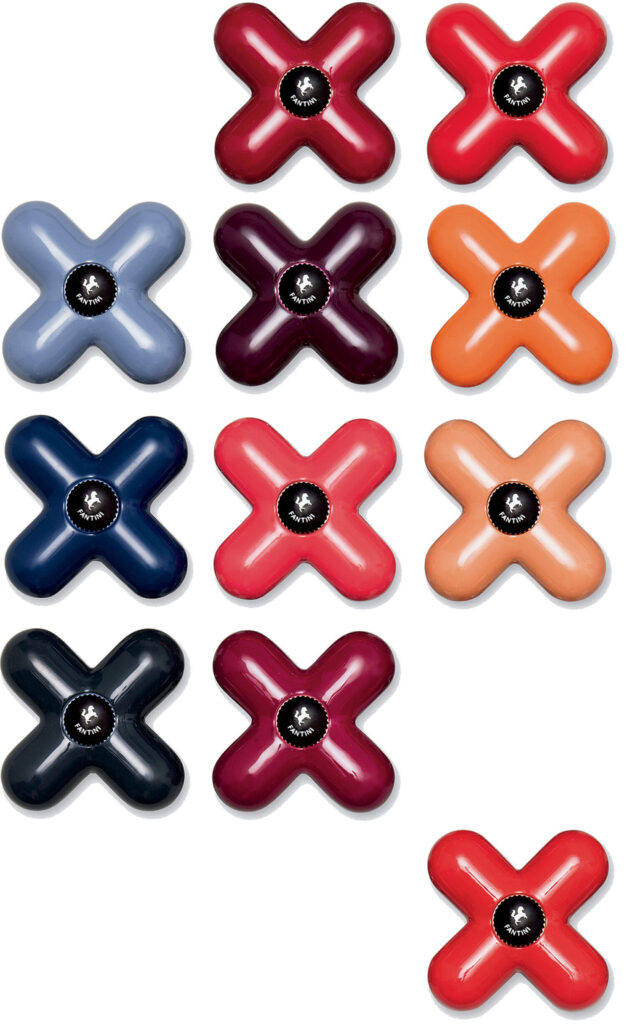 Twelve X-shaped objects in various colors, each with a circular black label in the center, arranged in four rows on a white background.