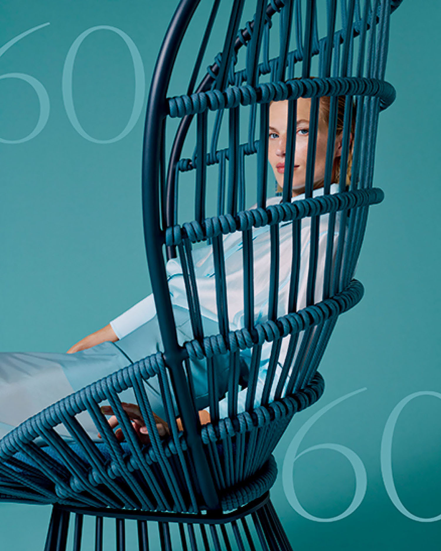 Person in light clothing sits in a modern woven chair against a teal background with the number 60 faintly visible.