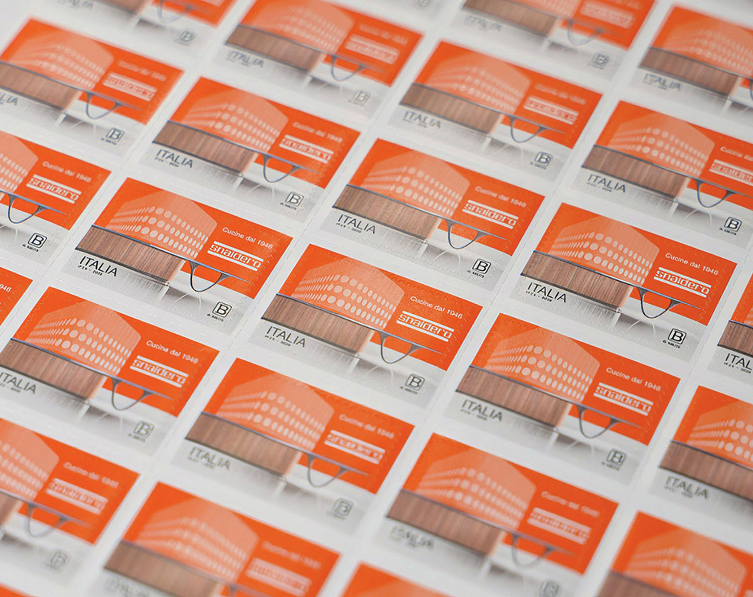 A grid of orange and white Italian postage stamps featuring a modern building design, arranged in neat rows on a flat surface.