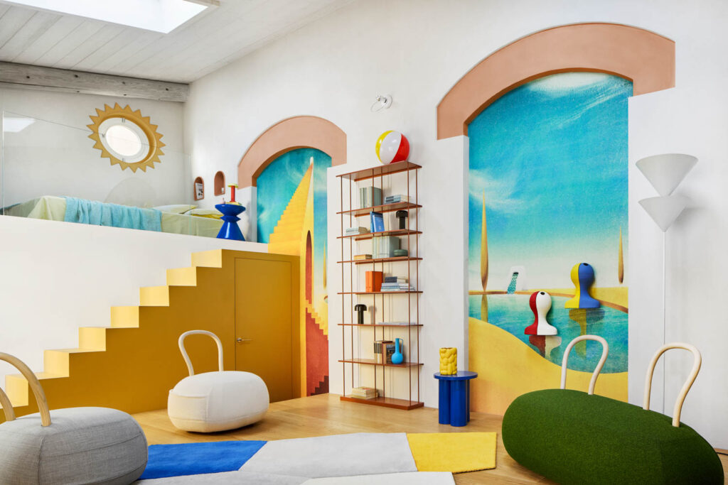 A whimsical room with a raised sleeping area, yellow stairs, colorful abstract murals, a metal shelving unit, and sculptural furniture.