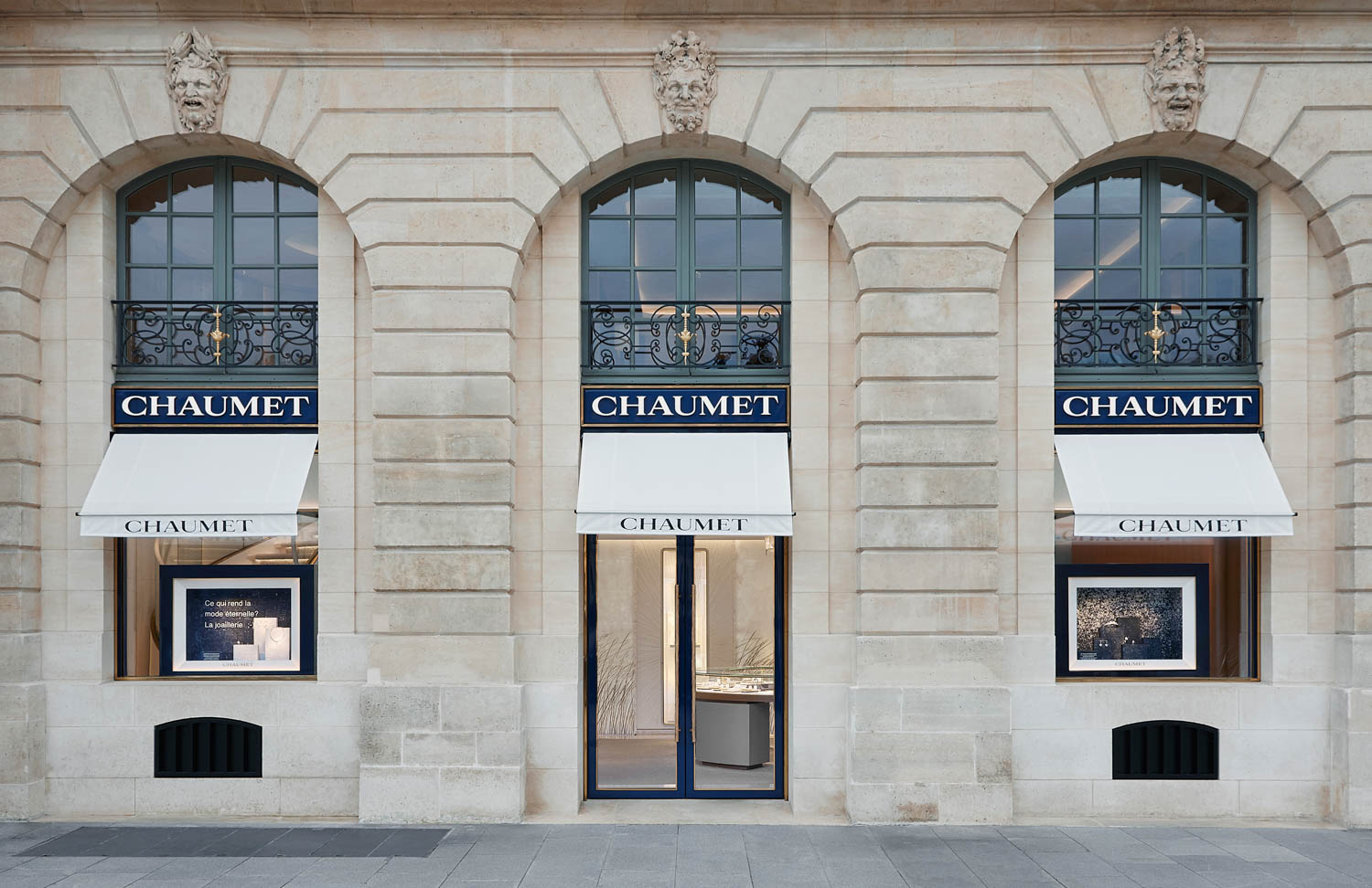 Chaumet storefront with three arched windows, branded awnings, and an entrance door.