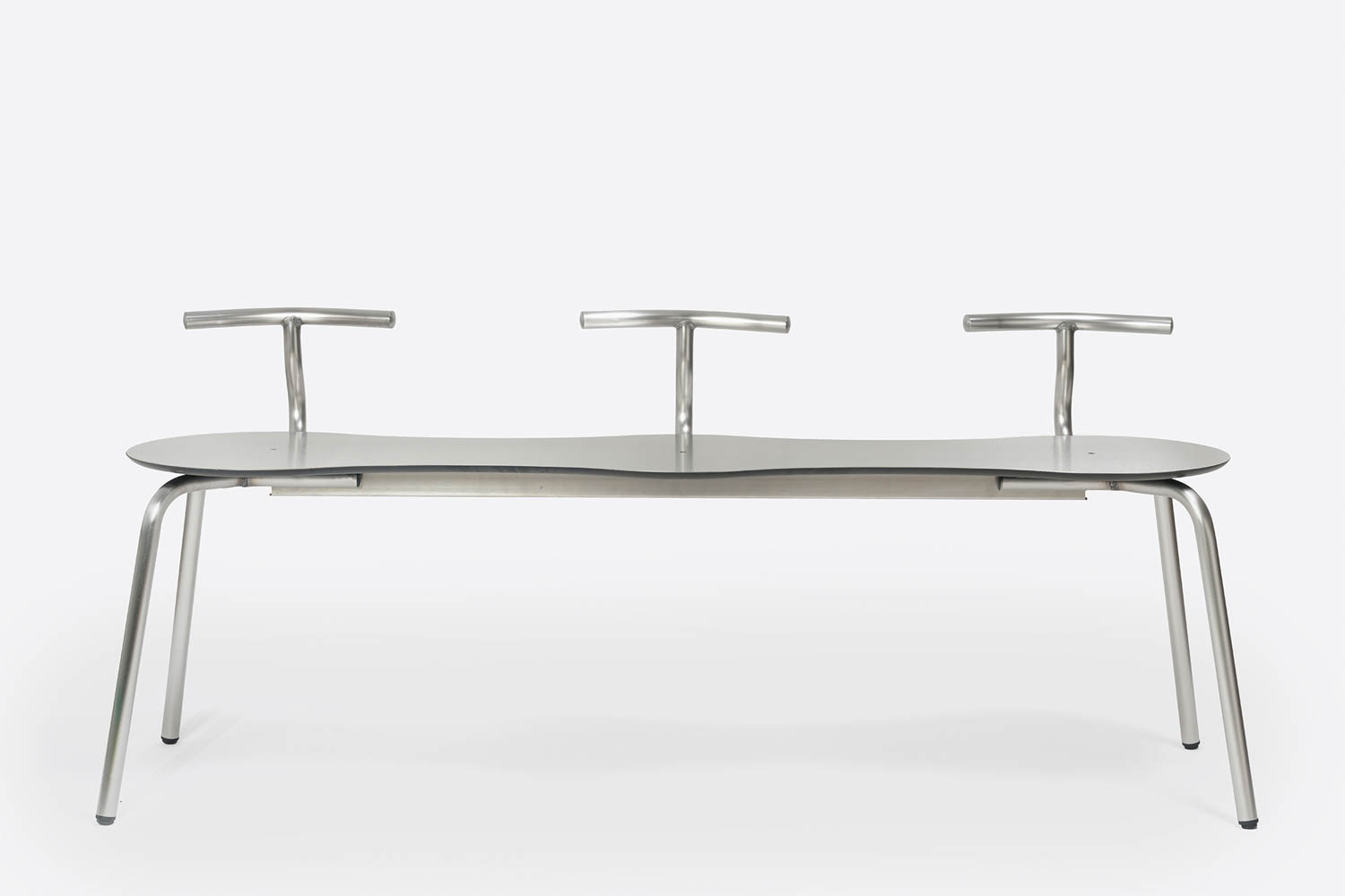 Modern metal bench with three minimalist T-shaped backrests and four angled legs, photographed against a plain white background.