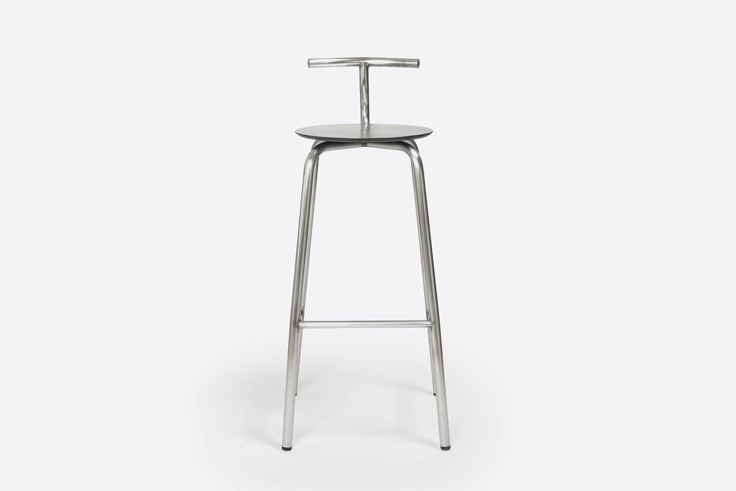 A metal bar stool with a round seat, four straight legs, and a T-shaped backrest, photographed against a plain white background.