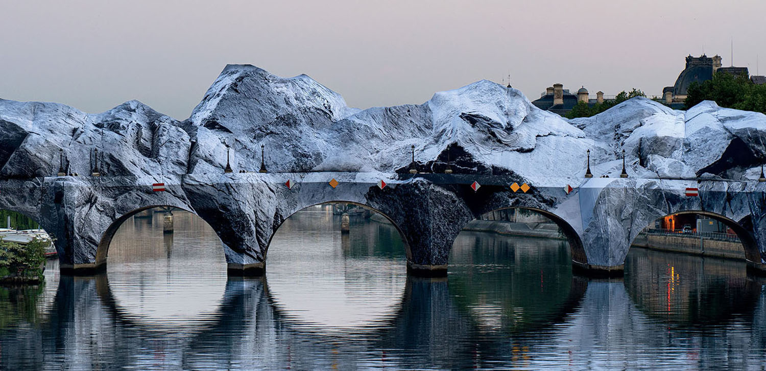 The Pont Neuf bridge in Paris wrapped in silver fabric, mimicking a jagged mountain landscape over the Seine.