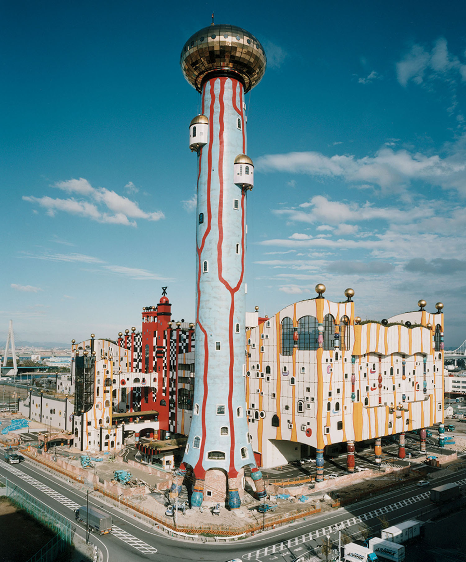 Maishima Incineration Plant in Osaka, a colorful building with a tall tower featuring a gold dome and irregular red patterns.