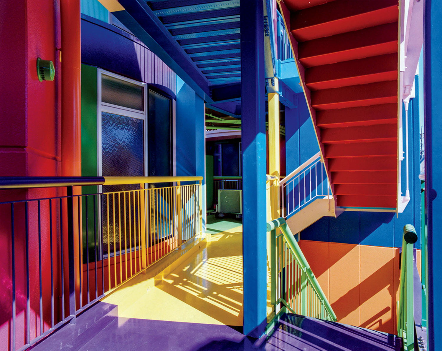 An outdoor staircase and walkway painted in bold, primary colors.