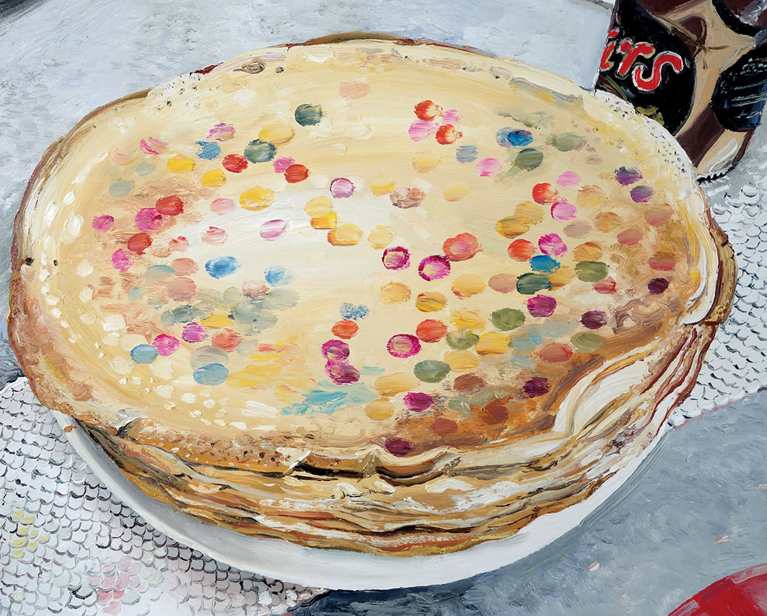 A stack of thin pancakes topped with colorful sprinkles on a white plate.